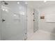 Modern shower with clear glass enclosure, built-in shelving, and updated shower head, offering a spa-like experience at 4710 W Tambay Ave, Tampa, FL 33611