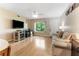Comfortable living room featuring hardwood floors, modern TV, and a cozy sofa at 501 E Bay Dr # 102, Largo, FL 33770