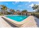 Community pool surrounded by lounge chairs and lush tropical landscaping at 501 E Bay Dr # 102, Largo, FL 33770