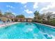 Sparkling community pool with lounge chairs and lush landscaping at 501 E Bay Dr # 102, Largo, FL 33770