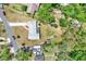 Bird's-eye view of the property with the roof, driveway, and surrounding area featuring lush greenery at 5068 Lakewood Dr, Ridge Manor, FL 33523