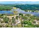 Aerial view of a neighborhood with a lake, surrounded by lush green trees, showcasing a serene setting at 5068 Lakewood Dr, Ridge Manor, FL 33523