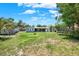 Expansive backyard featuring a large lawn, mature trees, shed, and a trampoline in a partially shaded area at 5068 Lakewood Dr, Ridge Manor, FL 33523