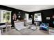 Bedroom featuring dark walls, three windows, crib, and a changing table at 5068 Lakewood Dr, Ridge Manor, FL 33523