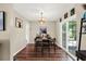 Cozy dining area featuring beautiful wood floors, natural lighting, and a sliding glass door to the backyard at 5068 Lakewood Dr, Ridge Manor, FL 33523
