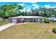 Charming single-story home with lush lawn, mature trees, and a driveway leading to an attached garage at 5068 Lakewood Dr, Ridge Manor, FL 33523