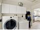 Laundry room with washer, dryer, and white cabinets for ample storage space at 5068 Lakewood Dr, Ridge Manor, FL 33523