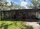 A screened back porch leads to a grassy backyard, perfect for outdoor living and entertaining at 5279 Eureka Springs Rd, Tampa, FL 33610