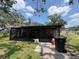Back porch with overgrown yard and trash can at 5279 Eureka Springs Rd, Tampa, FL 33610