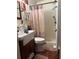 Bathroom featuring a pedestal sink with cabinet, walk-in shower, and patterned shower curtain at 5279 Eureka Springs Rd, Tampa, FL 33610