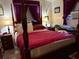Traditional bedroom featuring a four-poster bed with lamps and burgundy accents at 5279 Eureka Springs Rd, Tampa, FL 33610