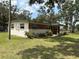 Single-story home with brick accents and a well-manicured lawn surrounded by mature trees at 5279 Eureka Springs Rd, Tampa, FL 33610