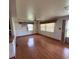 Bright living room featuring hardwood floors, ceiling fan and natural light through large windows at 5279 Eureka Springs Rd, Tampa, FL 33610