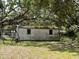 Exterior of small storage shed surrounded by overgrown vegetation at 5279 Eureka Springs Rd, Tampa, FL 33610