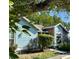 Charming home featuring a mix of blue siding and brick, complemented by lush greenery and mature trees at 5804 Red Cedar Ln # 5804, Tampa, FL 33625