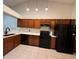 Traditional-style kitchen with ample wood cabinetry, sleek black appliances, and elegant tile flooring at 5804 Red Cedar Ln # 5804, Tampa, FL 33625