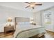 Bright main bedroom with wood floors, paneled accent wall, and a ceiling fan at 7211 Ronnie Gardens Ct, Tampa, FL 33619