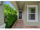 Inviting front entrance with brick walkway, lush landscaping, and a secure window at 7302 Sunshine Bridge Ave, Gibsonton, FL 33534