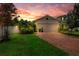 Charming single-Gathering home featuring a brick driveway, a two-car garage and sunset views at 7302 Sunshine Bridge Ave, Gibsonton, FL 33534