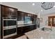 Modern kitchen with stainless steel appliances, granite countertops, and dark cabinetry at 7302 Sunshine Bridge Ave, Gibsonton, FL 33534
