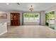 Bright living room features hardwood floors, a large window with blue curtains, and backyard access at 7302 Sunshine Bridge Ave, Gibsonton, FL 33534