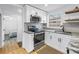 Updated kitchen with stainless steel appliances, granite countertops, and sleek gray backsplash at 750 49Th N Ave, St Petersburg, FL 33703