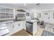 Open concept kitchen with white cabinets, stainless steel appliances, and convenient bar seating at 750 49Th N Ave, St Petersburg, FL 33703