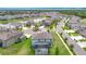This aerial shot showcases a neighborhood featuring a central lake, lush landscaping and well-maintained homes at 7628 Surf Reed Way, Wesley Chapel, FL 33545