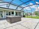 Outdoor entertaining on this screened patio with a hot tub and bar at 7628 Surf Reed Way, Wesley Chapel, FL 33545