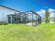Spacious backyard boasts a screened lanai and green lawn, perfect for enjoying outdoor living at 7628 Surf Reed Way, Wesley Chapel, FL 33545