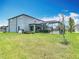 The backyard offers a screened lanai and lush lawn, ideal for relaxing and entertaining in privacy at 7628 Surf Reed Way, Wesley Chapel, FL 33545
