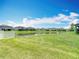 Expansive backyard view features a serene pond and well-manicured lawn, perfect for outdoor enjoyment at 7628 Surf Reed Way, Wesley Chapel, FL 33545