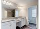 Bathroom featuring a double sink vanity with granite countertops and framed mirror at 7628 Surf Reed Way, Wesley Chapel, FL 33545