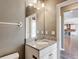Bathroom showcasing a granite-topped vanity and a view of the kitchen at 7628 Surf Reed Way, Wesley Chapel, FL 33545