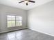 Bright bedroom featuring a ceiling fan, tile floor, and a window providing natural light and neighborhood views at 7628 Surf Reed Way, Wesley Chapel, FL 33545
