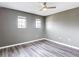 Bedroom with gray walls, ceiling fan, and two windows with natural light at 7628 Surf Reed Way, Wesley Chapel, FL 33545