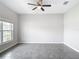 Serene bedroom with neutral color palette, ceiling fan and large window offering natural light at 7628 Surf Reed Way, Wesley Chapel, FL 33545