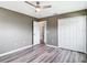 Bedroom featuring gray walls, vinyl floors, a ceiling fan, and closet with folding doors at 7628 Surf Reed Way, Wesley Chapel, FL 33545