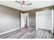 Bedroom featuring gray walls, vinyl floors, a ceiling fan, and closet with folding doors at 7628 Surf Reed Way, Wesley Chapel, FL 33545