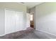 Bedroom showing carpeted floors, a closet and access to another room at 7628 Surf Reed Way, Wesley Chapel, FL 33545