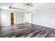 Spacious primary bedroom with tray ceiling, ceiling fan, and wood-look flooring at 7628 Surf Reed Way, Wesley Chapel, FL 33545