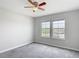 Bright bedroom with two windows, ceiling fan and neutral gray carpet at 7628 Surf Reed Way, Wesley Chapel, FL 33545