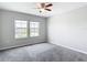 Neutral bedroom with a ceiling fan and bright windows at 7628 Surf Reed Way, Wesley Chapel, FL 33545