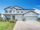 Gorgeous home featuring a three-car garage, beautifully designed facade, and pristine landscaping at 7628 Surf Reed Way, Wesley Chapel, FL 33545