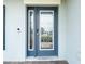 Elegant front door with decorative glass, digital lock, and sidelight, enhancing curb appeal at 7628 Surf Reed Way, Wesley Chapel, FL 33545