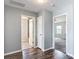 Hallway with wood flooring leading to the bathroom and a bedroom at 7628 Surf Reed Way, Wesley Chapel, FL 33545
