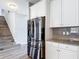 Kitchen featuring stainless steel refrigerator and granite countertops paired with sleek white cabinetry at 7628 Surf Reed Way, Wesley Chapel, FL 33545