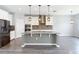 Modern kitchen features stainless appliances, granite countertops, pendant lighting, and gray subway tile backsplash at 7628 Surf Reed Way, Wesley Chapel, FL 33545
