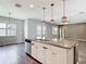 Modern kitchen with a large granite island and stainless steel appliances, offering an open concept design at 7628 Surf Reed Way, Wesley Chapel, FL 33545