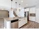 Island kitchen showcasing granite countertops, stainless steel appliances, and an open floor plan at 7628 Surf Reed Way, Wesley Chapel, FL 33545